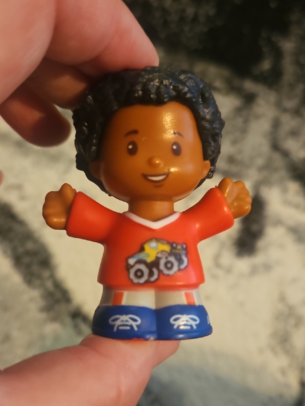 Fisher-Price Little People Chris figure wearing a red shirt with a monster truck